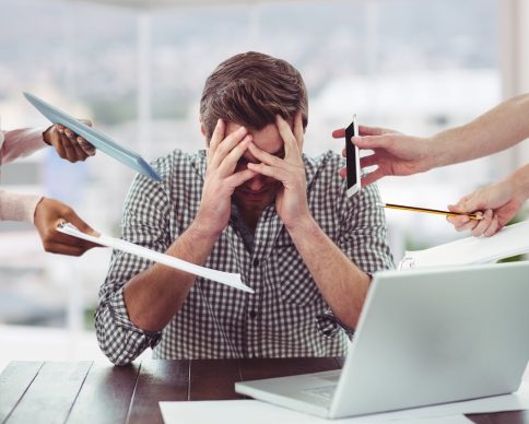 Stressed man frustrated with electronic devices in office