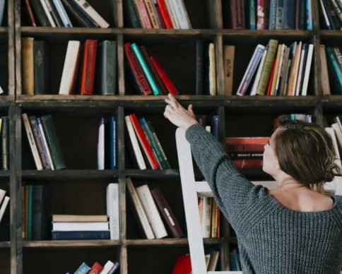 back-view-woman-choosing-book-from-shelf
