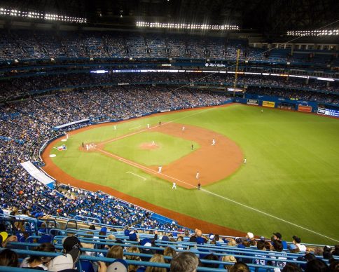 A horizontal shot of crowded Yankee baseball stadium and players in the field
