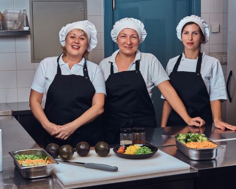 Happy cooking team wearing a uniform standing next to a table with chopped vegetables, posing for a camera at a restaurant's kitchen. SSUCv3H4sIAAAAAAAEAIVTy27bMBC8F+g/GDxbAN+PfEUvRQ9BD3zJJiKJrkSlDQL/eynZsmnFTm7anVlxd3b2/fu3zQYYPQQLnjbvU5Tj0DTjkHqdQuxyGm7Pee9Cin3QzZSccscZAUPSaRz8UPwCYdLXOSZLrQm7IUX7ctjHFEvA6u4+4PwhDiHN+eEG6L1uhxRaX2brTGuCLlOH2DlWJob9mJLv5/emfDGD1cnv8nA3UyzCPJ/izQKcG08ZAj98PDQebAtkGM2E/Iqt78CSP24/+cm98mvl6eP3MoXe+c6+TW0eiwF633h9WsLzIm0NITFaVLUlvqJMmso44iqKKWa+tobaS+MAQou5gplMNamoRa7S0MFK1EwwwyVSFl7IStfQcFRX0mmV/2xJZTKt8pBDLyQX3oi5/1PT4OVvlr2dpT23+xqcj0WsRxdiIf1rtLoZVks69MGGbleUxbT3fRHbbNzYFokuplmTs8TA5T1PISJIijwvQkJBRhA8DwdmcwRX2mBlG/ATEcYY4VBI8MitAGMhhcSMgrUdgZKSIs4ZuOvo3BpmuVAK8NHbAE9Ps9w1eHRZAAvI8xNEgUc3BjihSkJCLozlXkH978+oXR+RRCiLozj4cOj7kH/WvxUCjYcmaufdNXXTNGI0q00lFReb3468EBgrCCtBLxx+5aznWjhcXTmL6gsm4BVbLfZEYYoUlEWYGVMQKnTF1spPHAypUvREWU5+uug25JduBbr7usrlX4mgsvkeDagEQp+qrBSn20dLygNS9cWAiCKFP9/BmlOKiBFHAp8FKrwV3GxMRykxjlbCClNRiXWlplBrIR22gjKPsyOP/wEIb3b5uQYAAA==
