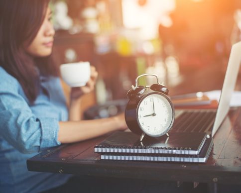 Beautiful hipster woman using laptop at cafe while drinking coffee.