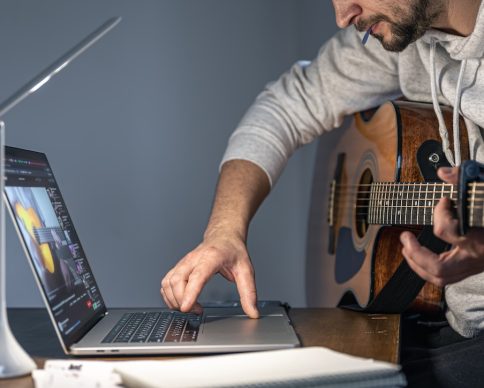 A man with an acoustic guitar in front of a laptop at a later time learns to play, online music training, hobbies, video training. SSUCv3H4sIAAAAAAAACpySwW7DIAyG75P2DhHnRkpKGpK9SrWDQ0iDSqEC0mmq+u4zECrOu8Wf7d/+TZ6fH1VFJnCSk6/qGSKMpVKb8xa8NBpxc9i5FXoWtiQPS/umBGKW3lgJqoQTeL5quAmEelMq4FdMEufBb064MH1HHLy4oEaCb4m04jnFVU7EJHZgipBDwdw2RZZREv9XZ/r4zm7gIjT/jQsXRqxQApKRcyol1x8v7K20BtssTeHqYTioUEALpbuVXOpL0Wb8Gs+e27jZtLdhhffmRBlzh0mFEy+oKTJfwTksnzMvBnF8ZHMr5mjjo4Fdlcz4EiFs6XGgjJ5O/dCwllF63AvS660SdeI6WQhjfpVzaV2GDfD3aJfTCF3Nxo7X3dAPNTR0rJeR0ZGxtu26Hg//+gMAAP//AwBoEA9wmAIAAA==