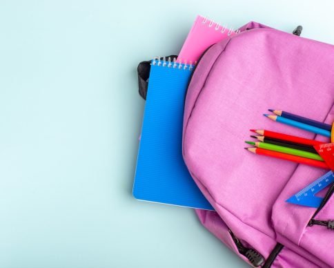 top view purple bag with copybooks and pencils on blue desk color photo school drawing children