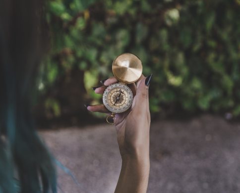 woman-looking-golden-vintage-compass-hand
